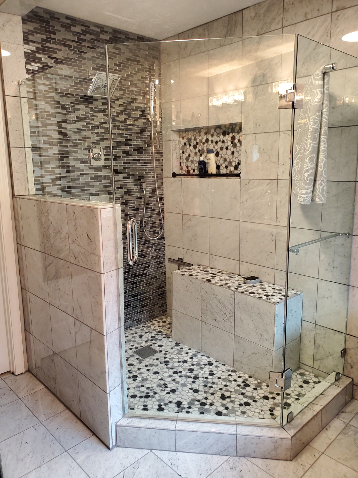 Glass-to-glass hinged door using a support bar on the panel for additional strength.  Notice a towel hanging off support bar.